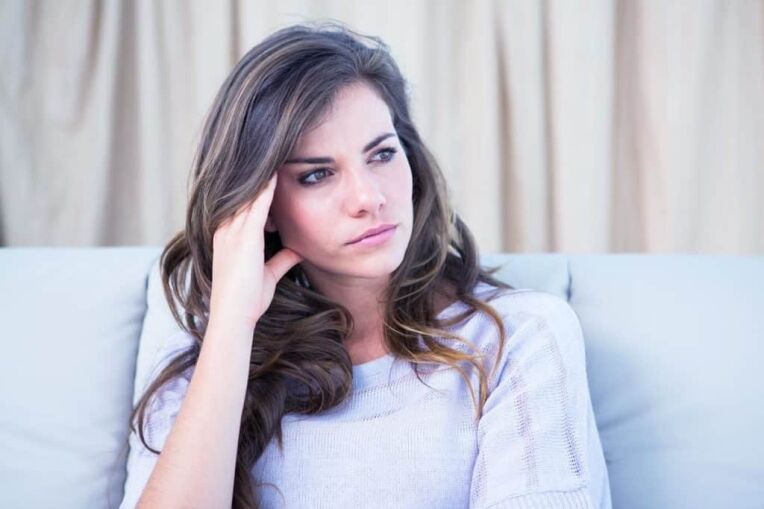 a lonely woman sitting on a sofa with Depersonalization disorder